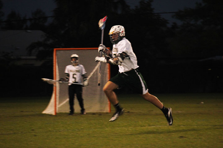 Senior Tim Nutter runs the ball away from the Falcons goal while goalie 