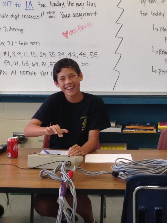 Tyler Popp, a member of one of the advanced teams, poses near a buzzer system used to play certamen.