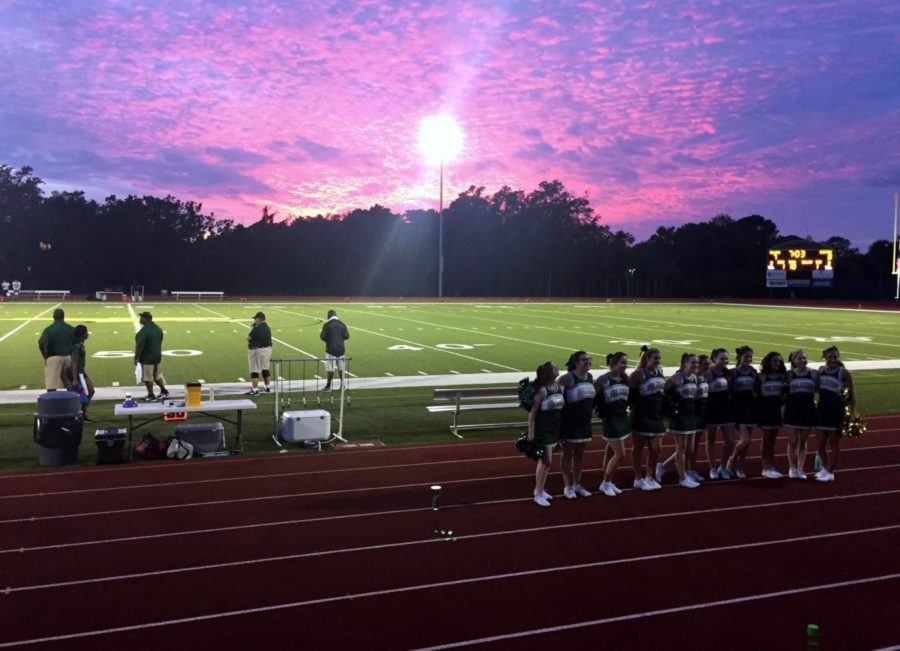 The Falcon cheer leading squad, led by head coach/theater director Jeannine Elisha, stands arm and arm before a beautiful sunset during Fridays game against Gateway Charter of Fort Myers. 