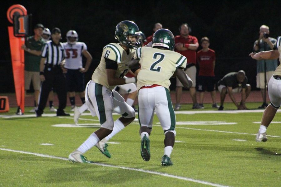 Quarterback, Xavier Williams, hands the ball off to running back, DJ Clark