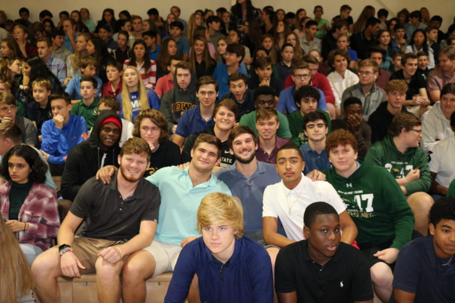 Football players gather together as they await to be called up.