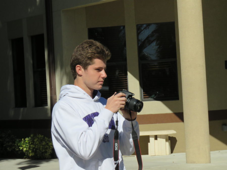 Senior Jarrett Millican taking photos in the Palm Courtyard.