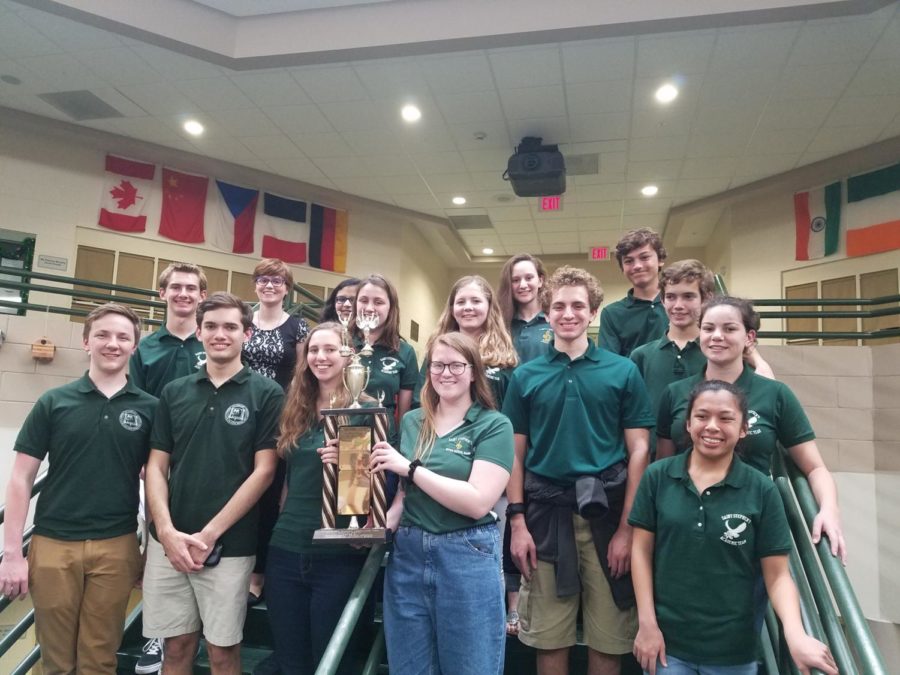 The+2018-19+academic+team+poses+for+a+group+photo%2C+proudly+presenting+their+trophy.