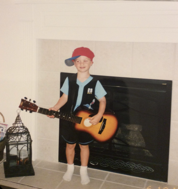 Aiden at age 7 trying to play the guitar.
