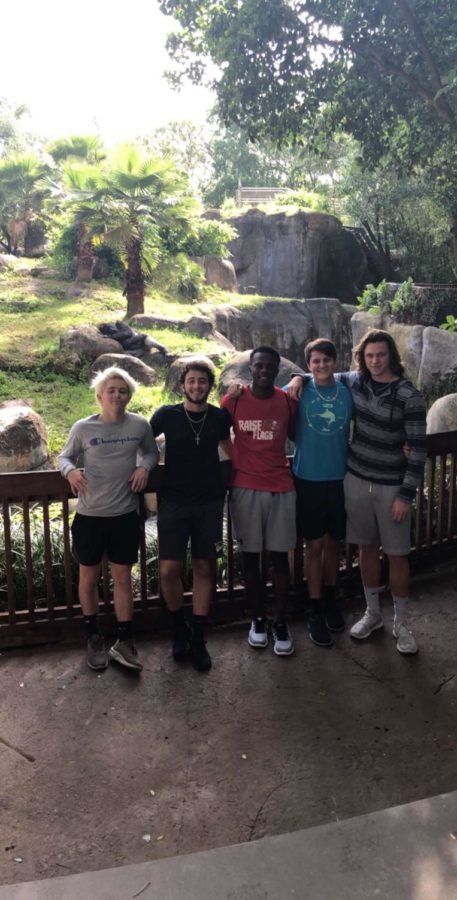 A gang of friends huddle up to take a picture with the gorilla.