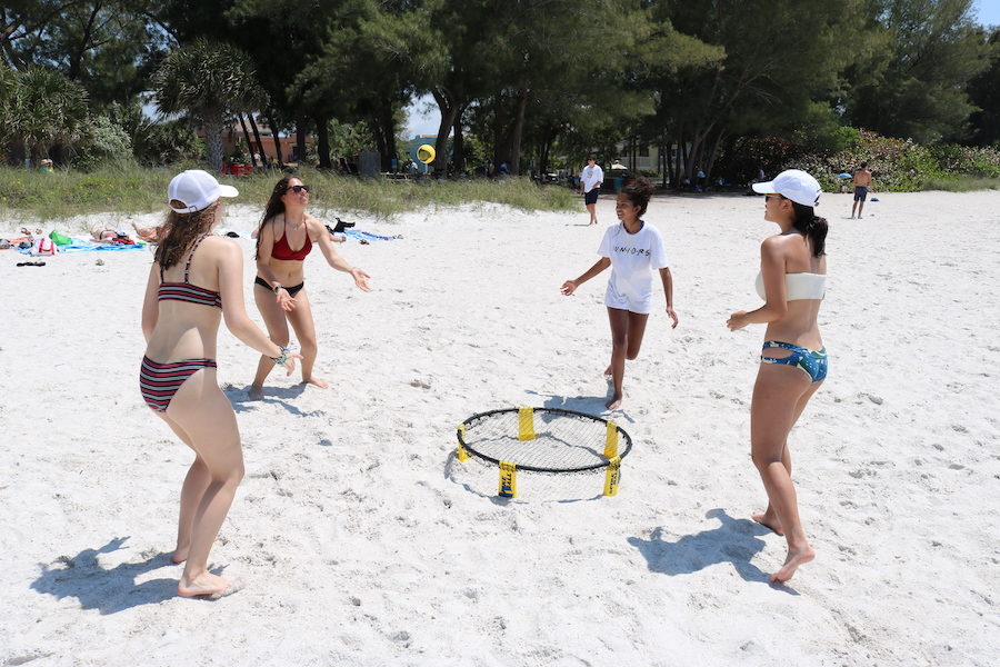 A group of junior girls play spikeball.