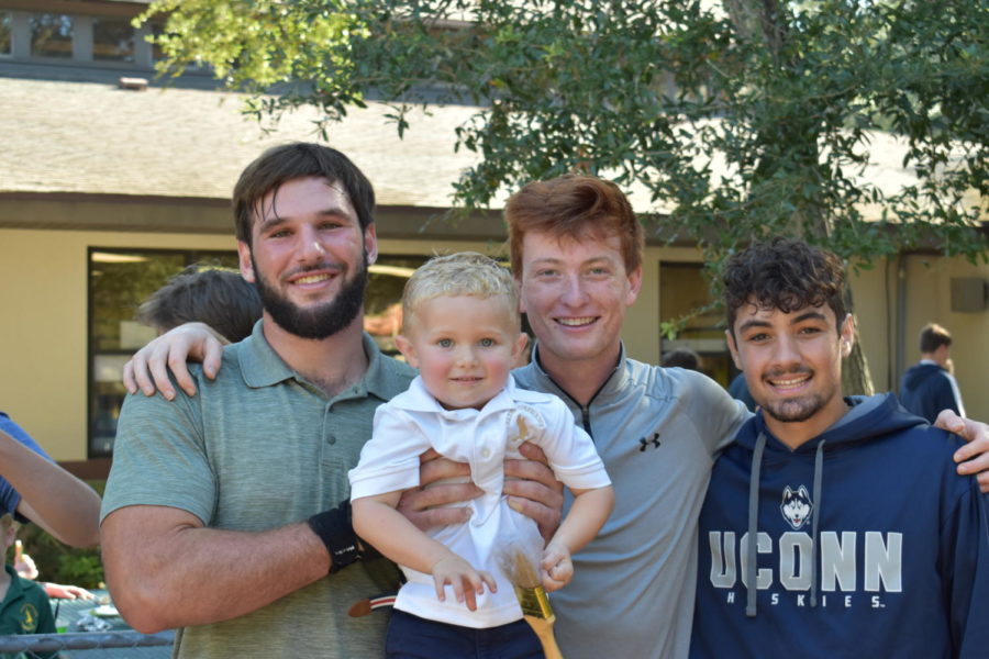 Seniors Dylan Davis, Jacob Whorf, and Ethan Kast smile with their falcon friend, Ronan DAgostino.