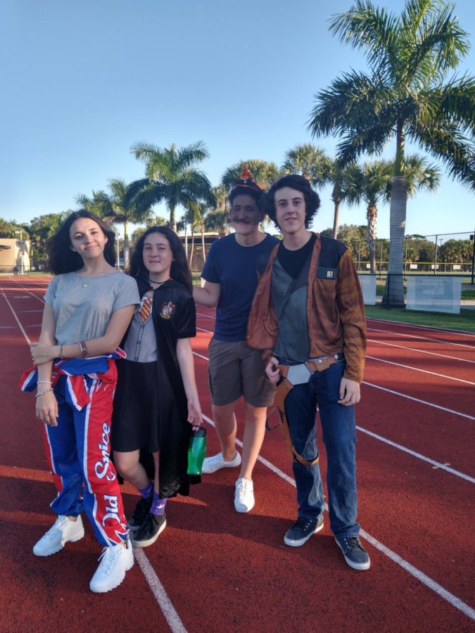 Four students pose on the football field excited to celebrate this first American Halloween