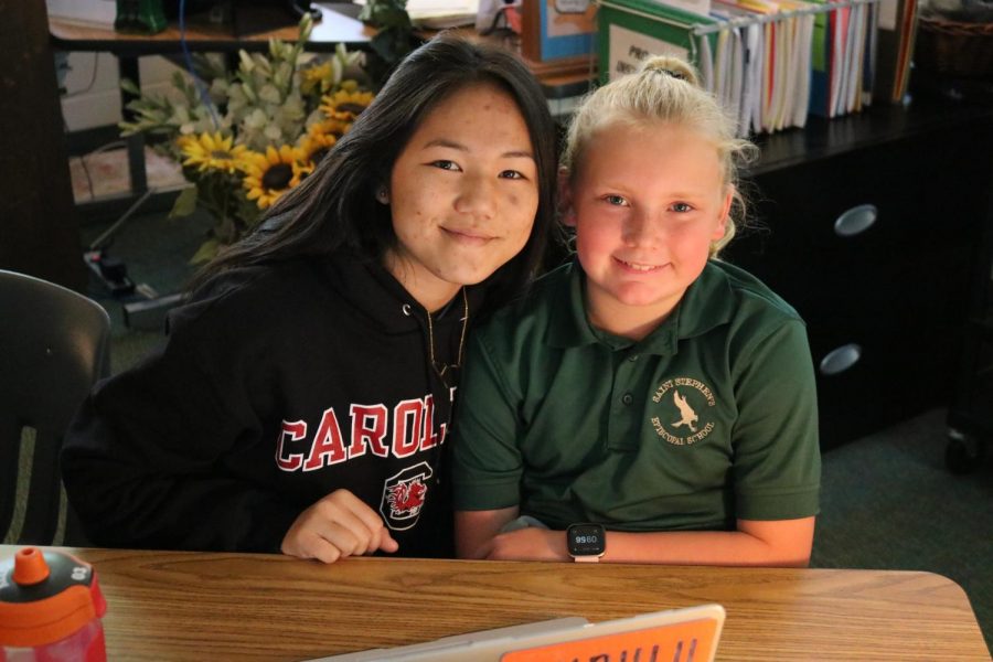 Junior Allie Serterides smiles with her fifth-grade Falcon friend.