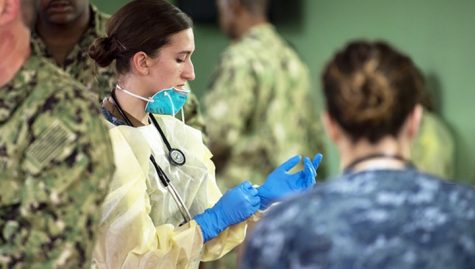 American health workers donning protective gear.  Photo credit: U.S. Navy