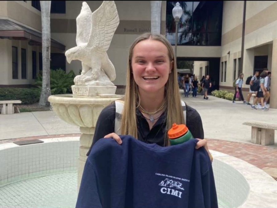 Sarah Black proudly holds up her camp sweater in the Palm Courtyard.