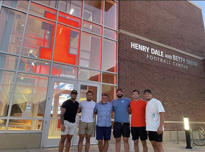 Chase Brown, Sydney Brown, Dylan Davis and Peyton Vining reunite with their former coach after practice.