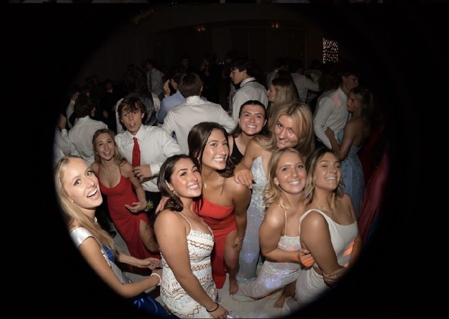 A group dancing in their special prom dresses, excited to hit the floor.