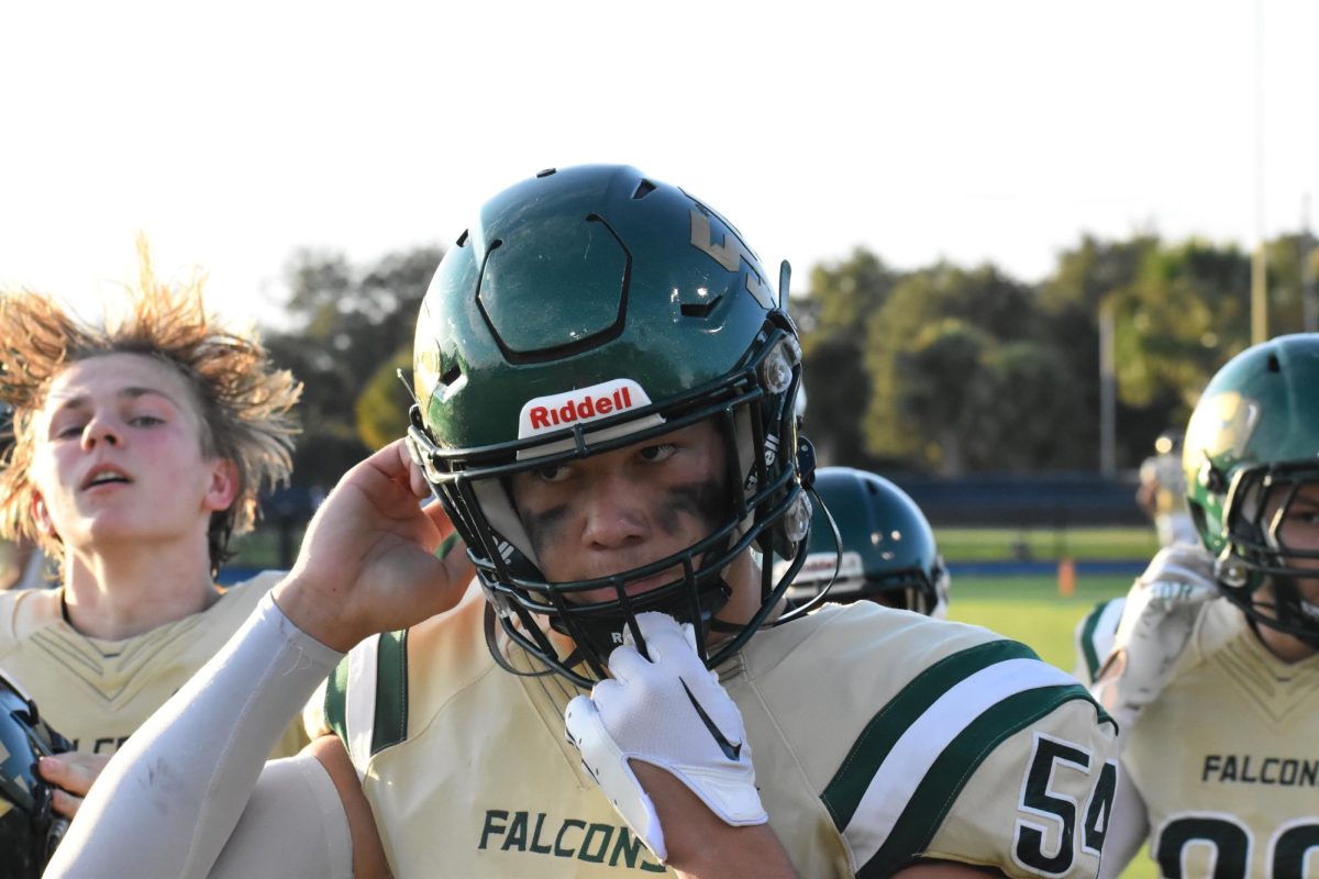 Senior Ivan Tulupov pulls down his helmet, ready for the next play. 