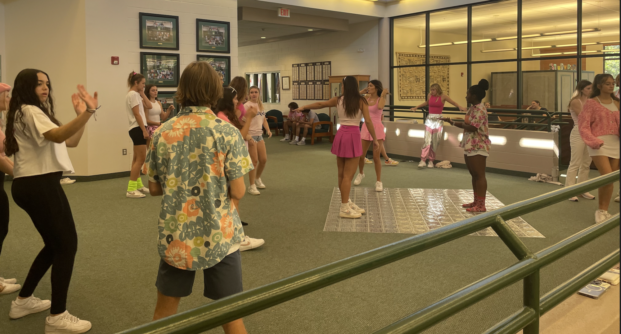 Shot of the juniors practicing their dance off, a well-oiled machine, outside the Sunshine Library.