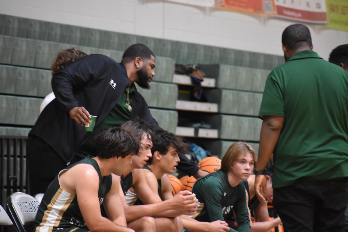 The team focuses in to their coach give his motivational speech
