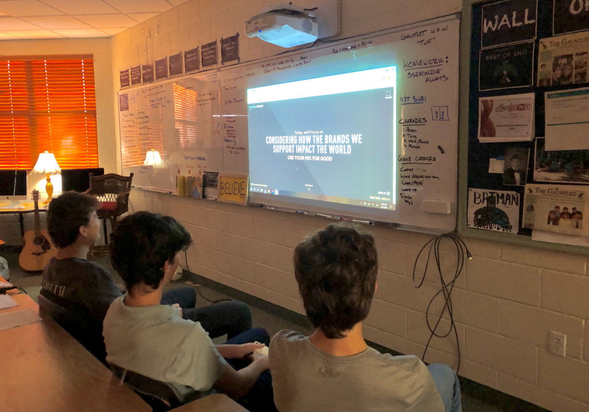 A group of sophomore boys (Dylan Kinder, Jackson Pakbaz, George Frano) take part in a lesson demonstrating how the brands we support impact the world. 