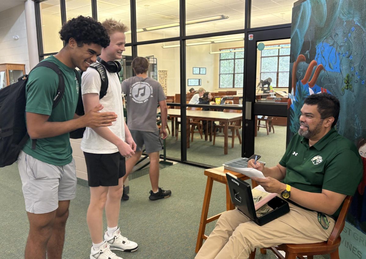 Mr. Frank Casaine outside of the Sunshine Library, interacting as he often does in the hallways with students
