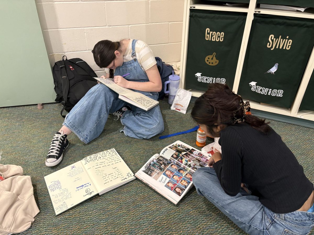 Seniors signing this years yearbook, themed constructing moments. 